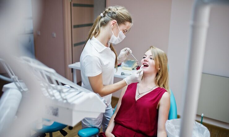 attractive patient red violet dress laying dental chair while female dentist treating her teeth with special instruments 151355 2541