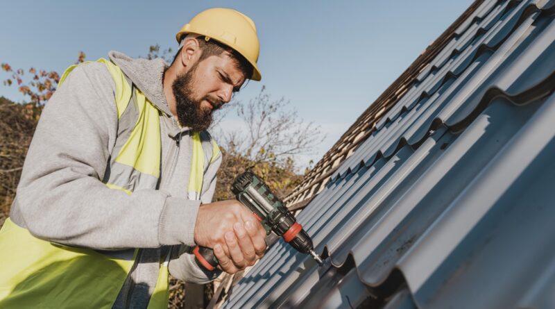 sideways man working roof with drill